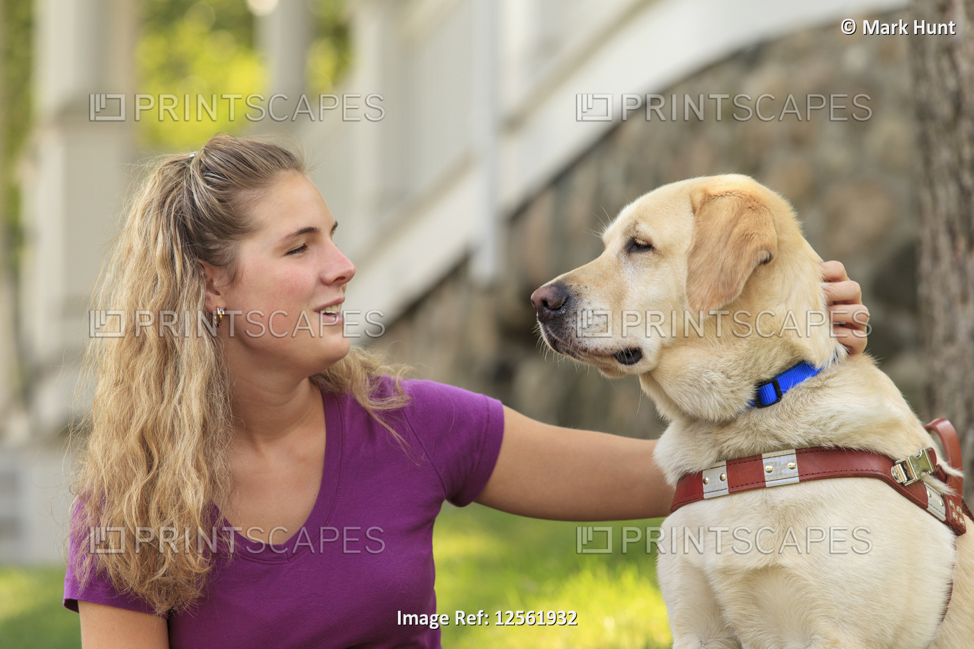 Woman with visual impairment petting her service dog