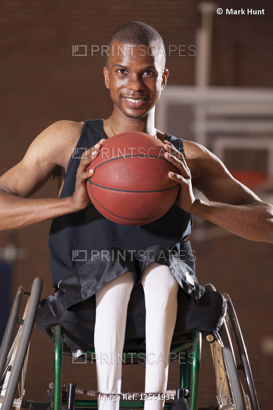 Man who had Spinal Meningitis in wheelchair holding basketball