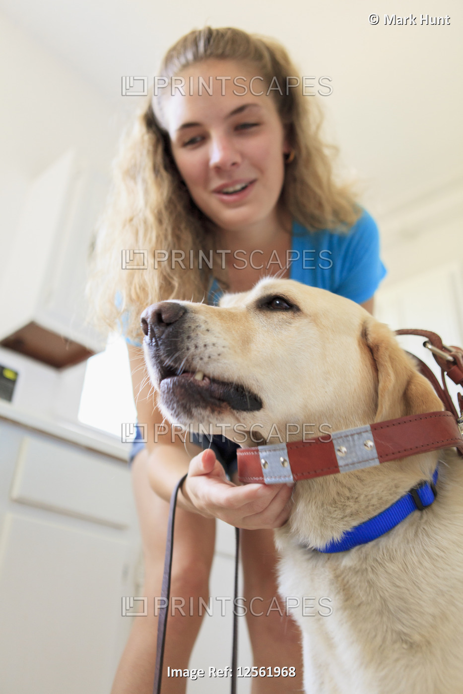 Woman with visual impairment putting the belt on her service dog