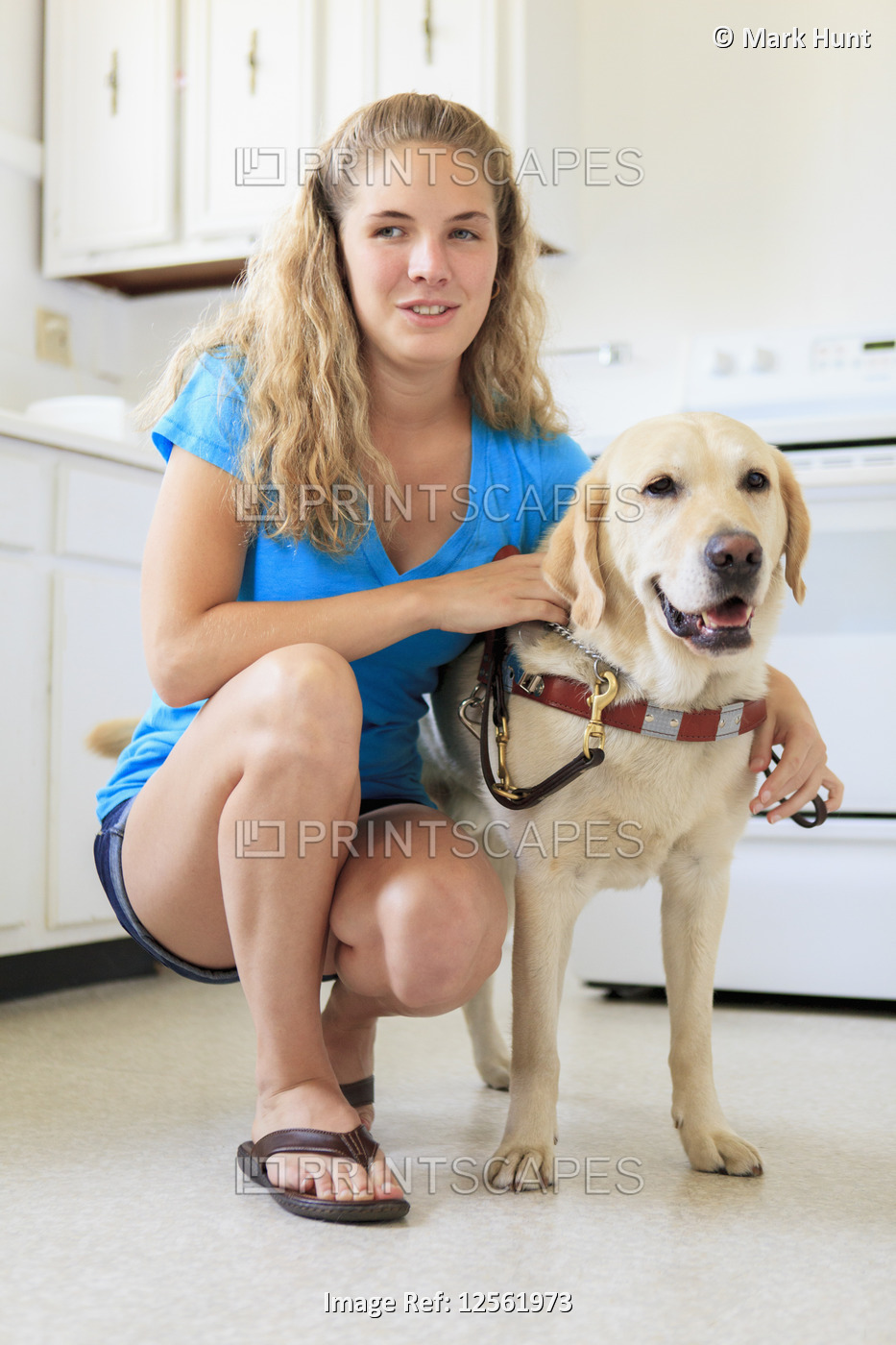 Woman with visual impairment in kitchen with her service dog