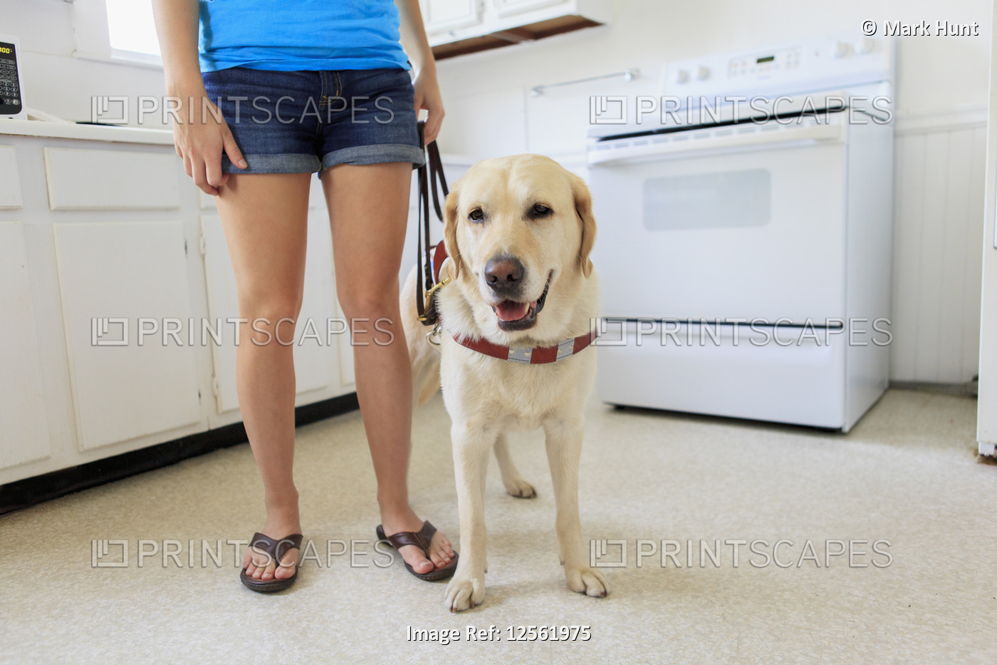 Woman with visual impairment in kitchen with her service dog