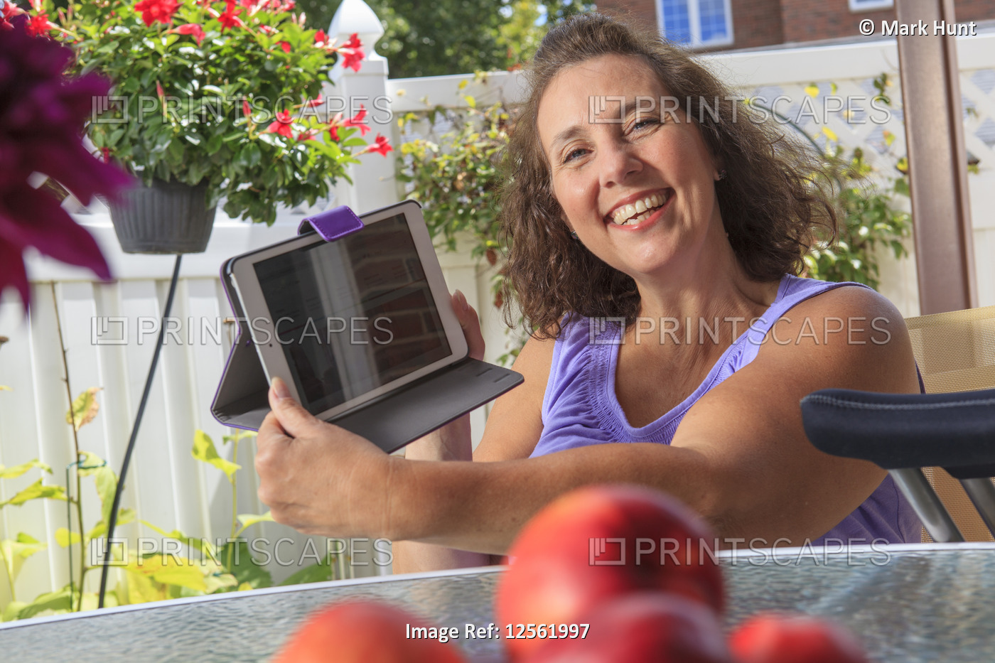 Woman with Spina Bifida on patio working on tablet