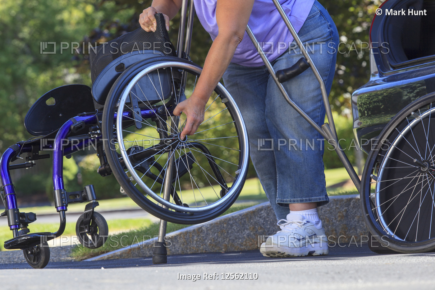 Woman with Spina Bifida using crutches to put wheelchair together after ...