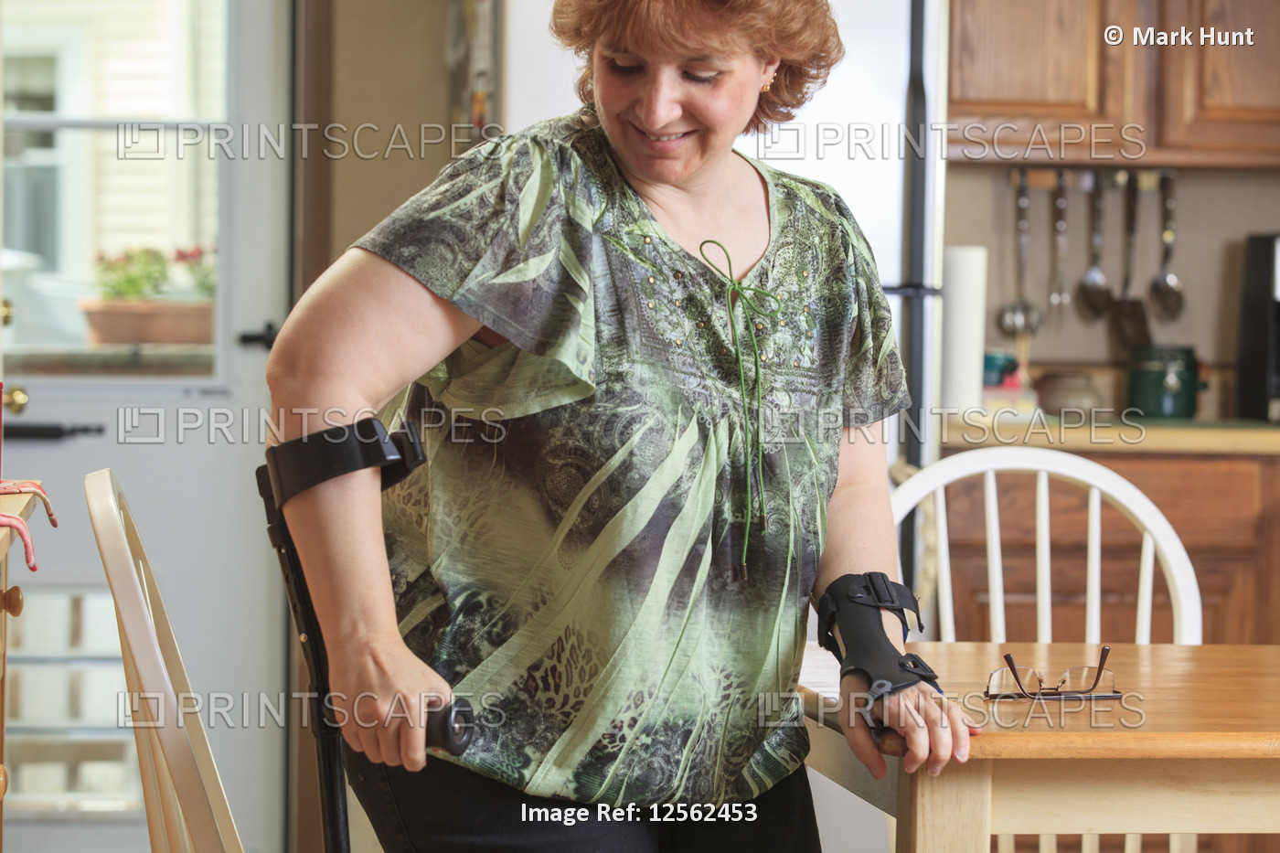 Woman with RSD using her hand brace and crutch at home