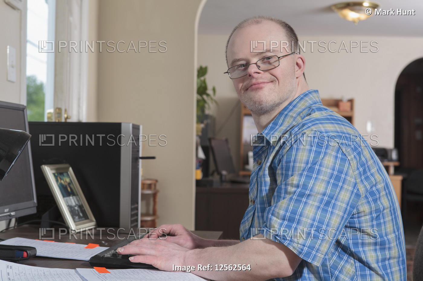 Man with Down Syndrome working at a computer in an office