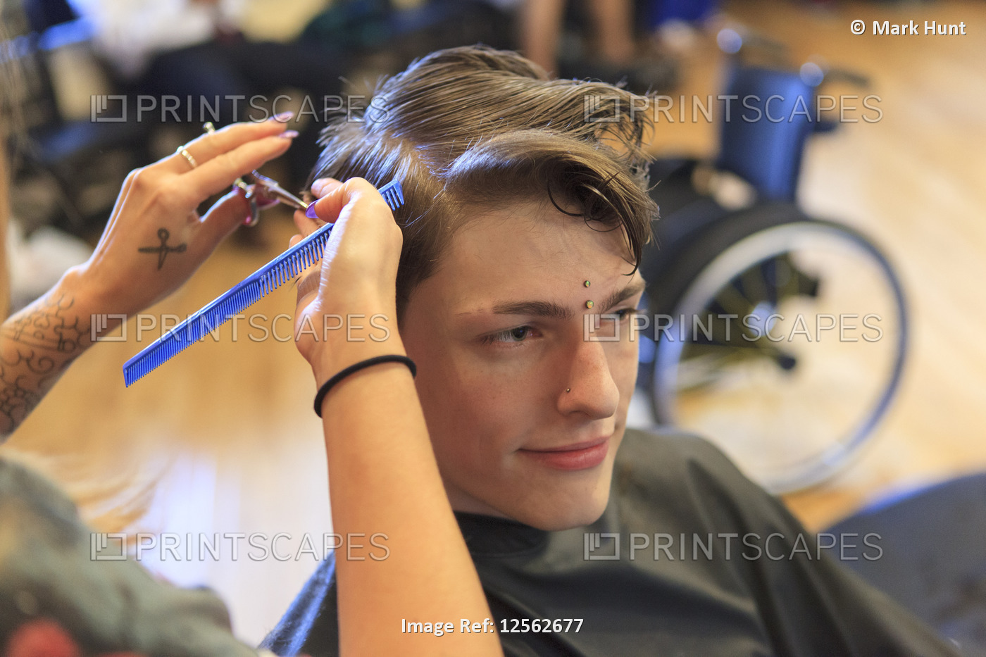 Trendy man with a spinal cord injury at a hair salon getting a hair cut