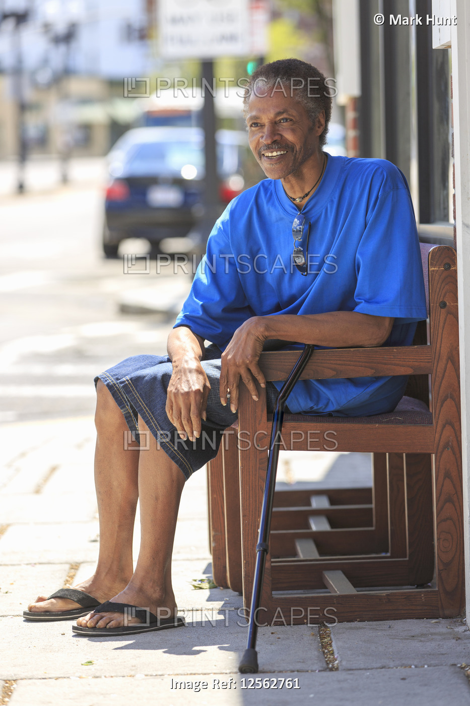 Man with Traumatic Brain Injury relaxing with his cane near the city street