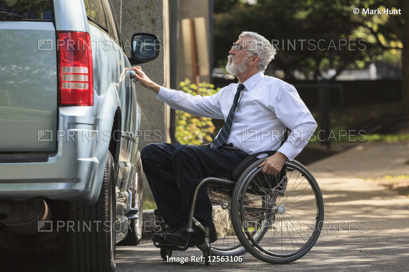 Businessman with Muscular Dystrophy in a wheelchair entering his accessible van ...