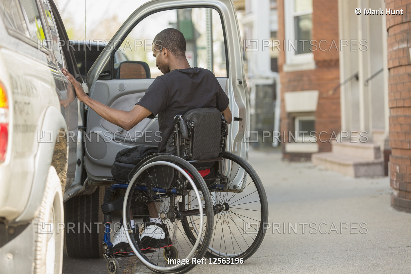 Man in a wheelchair who had Spinal Meningitis entering his accessible vehicle