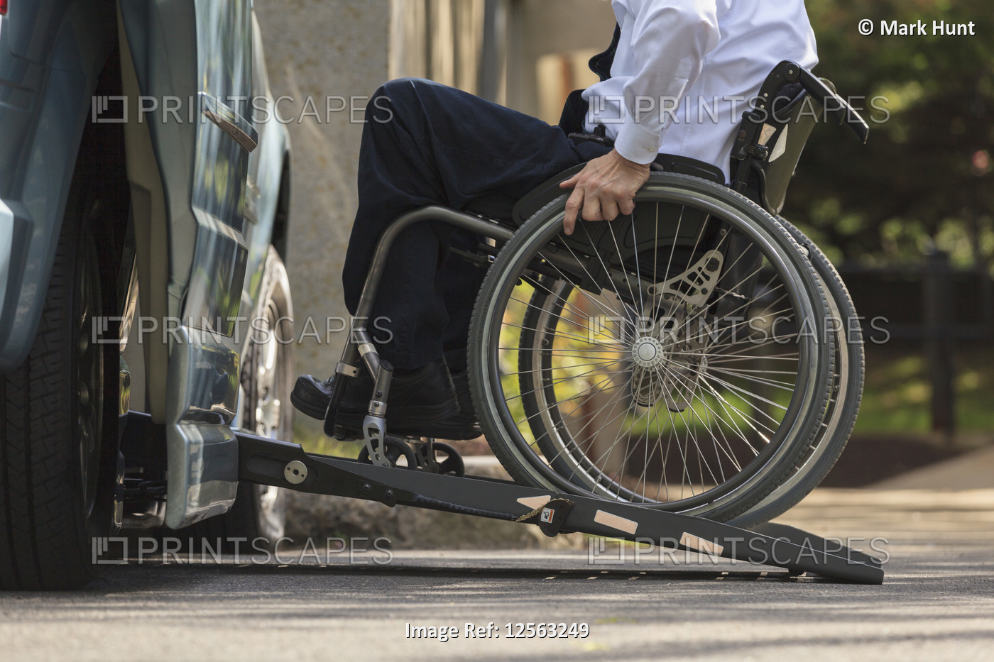 Businessman with Muscular Dystrophy in a wheelchair entering his accessible van ...