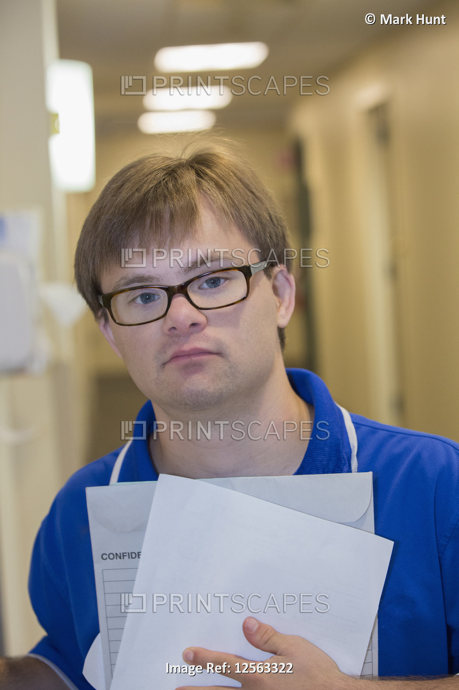 Young man with Down Syndrome delivering paperwork in a health clinic