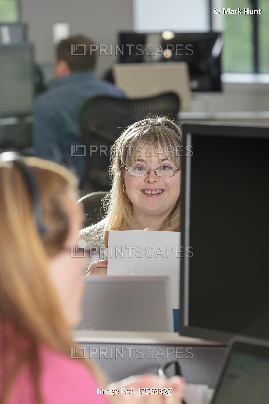 Young woman with Down Syndrome working at her computer in an office