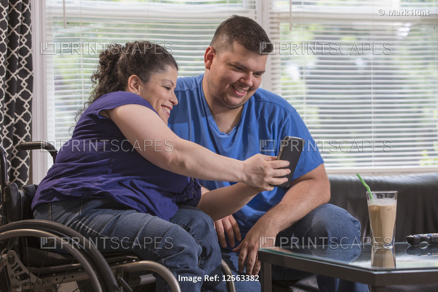 Woman with Spina Bifida and her husband looking at a text message at home