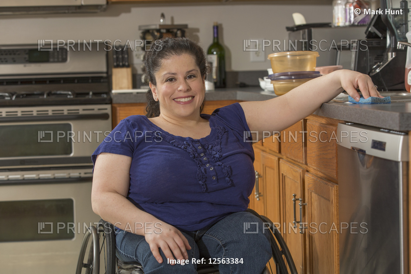 Portrait of happy woman with Spina Bifida cleaning her kitchen