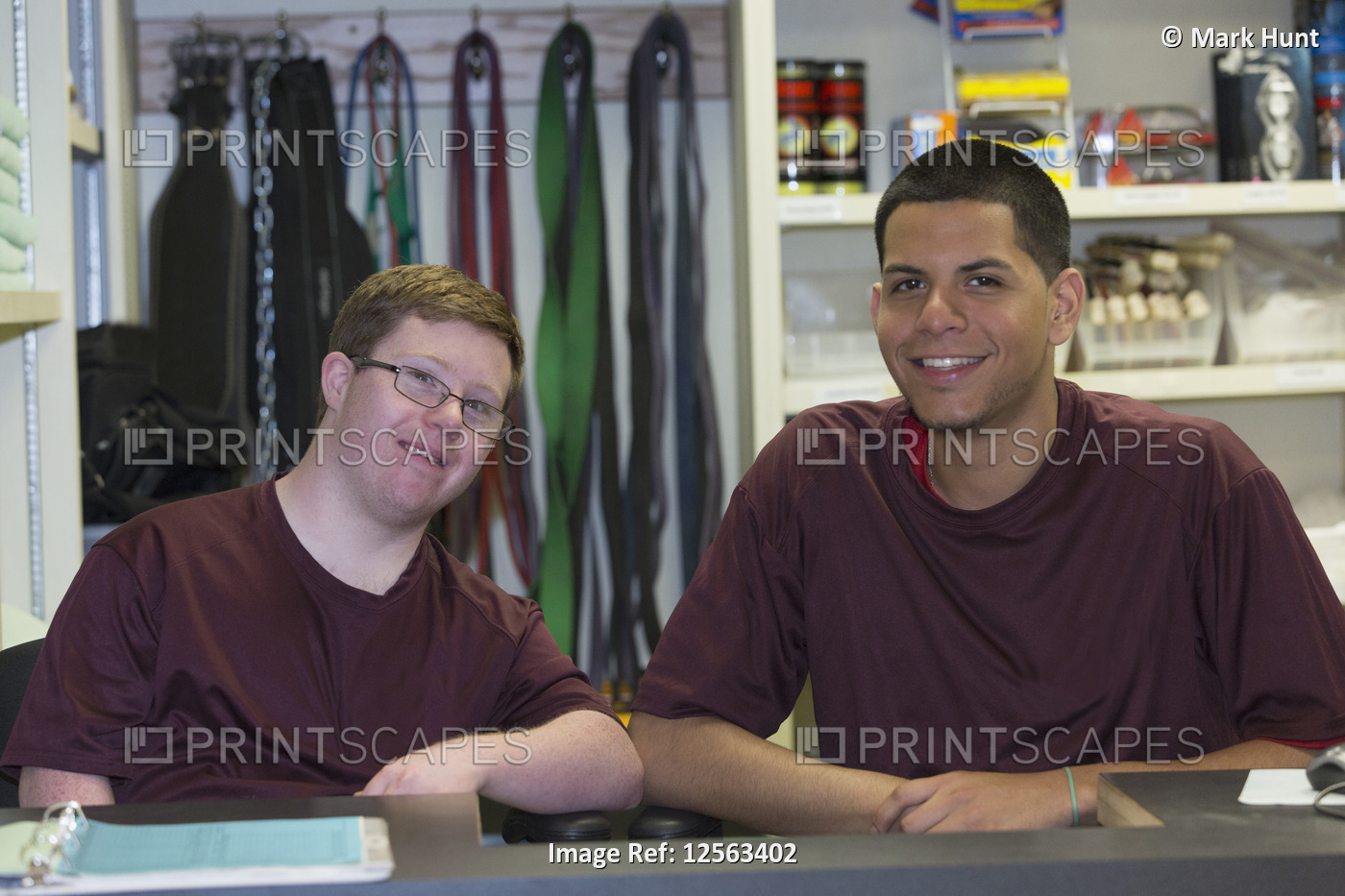 Young man with Down Syndrome working at college equipment dispensary for gym ...