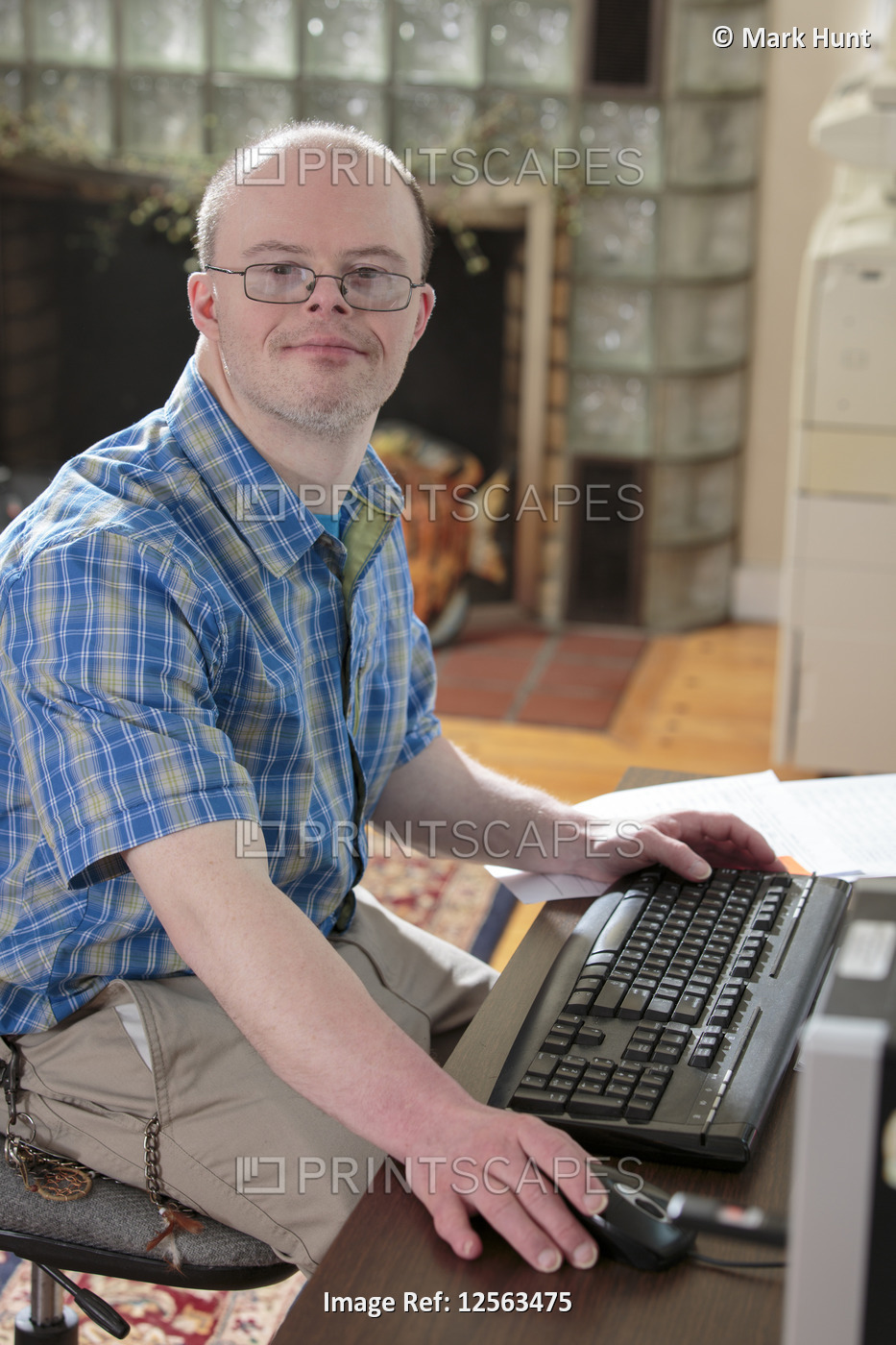 Man with Down Syndrome working at his computer in an office