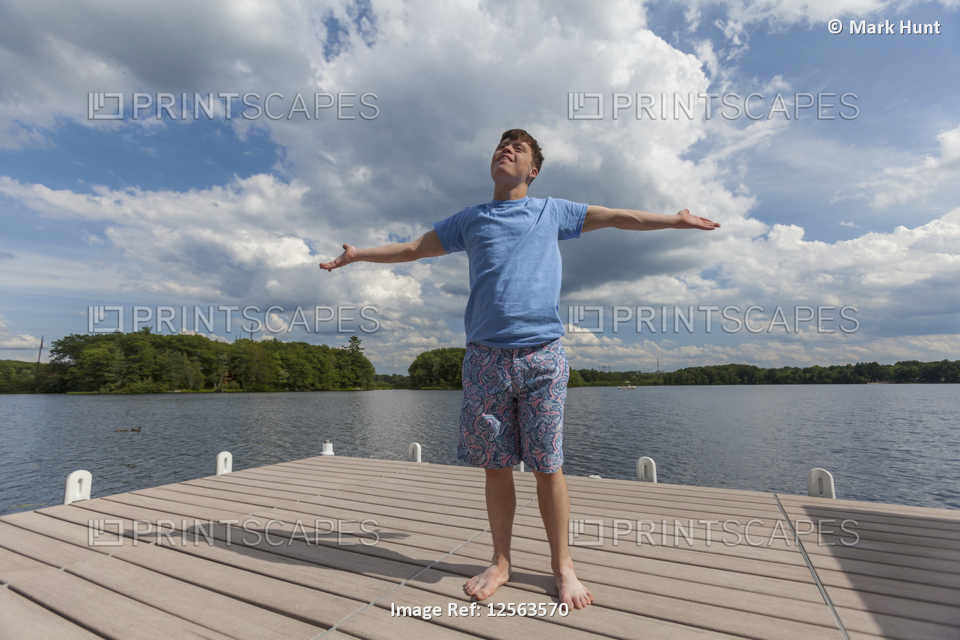 Young man with Down Syndrome standing on a dock