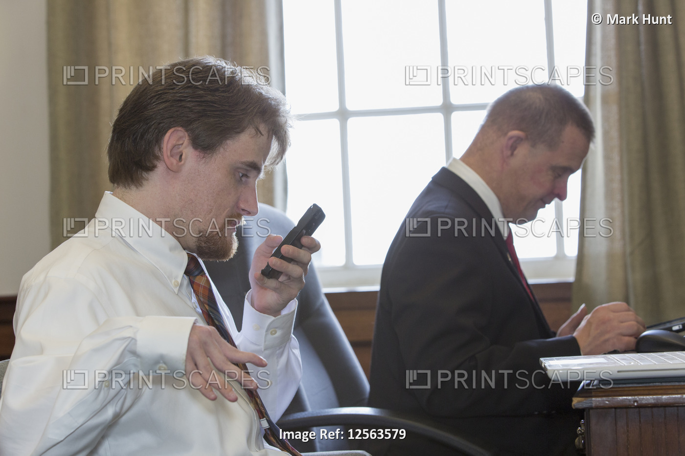Man with Down Syndrome working with a collaborator using a phone in the State ...