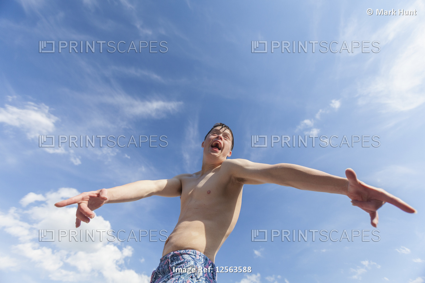 Young man with Down Syndrome playing on a dock against a sky