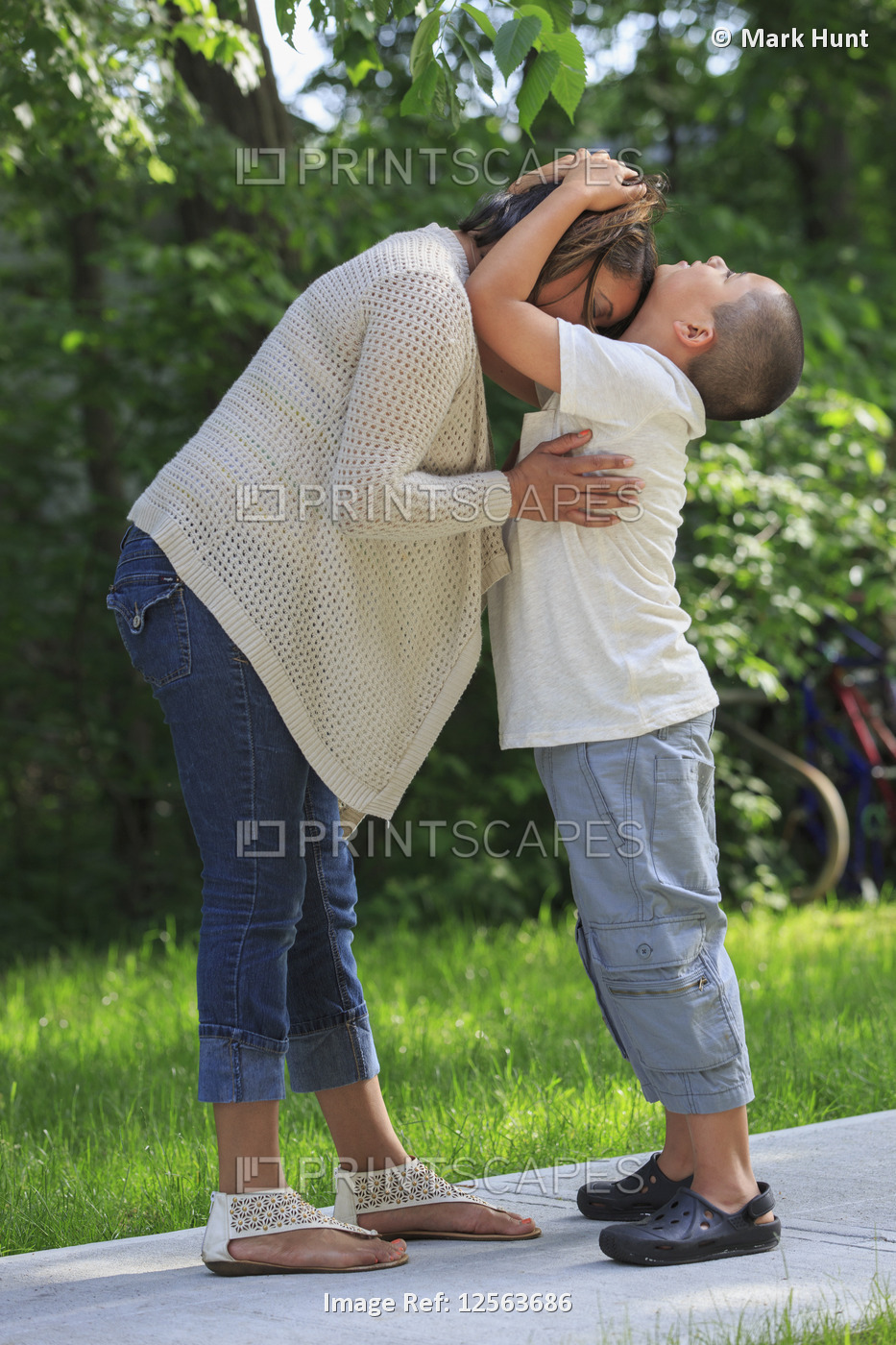 Hispanic boy with Autism hugging his mother in park