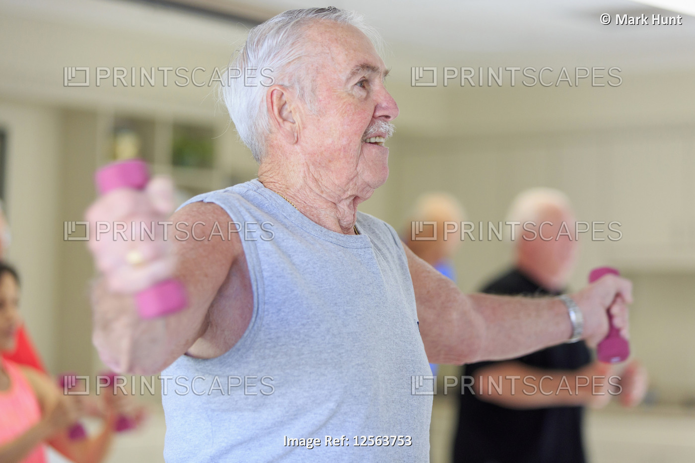 Happy senior man exercising in gym