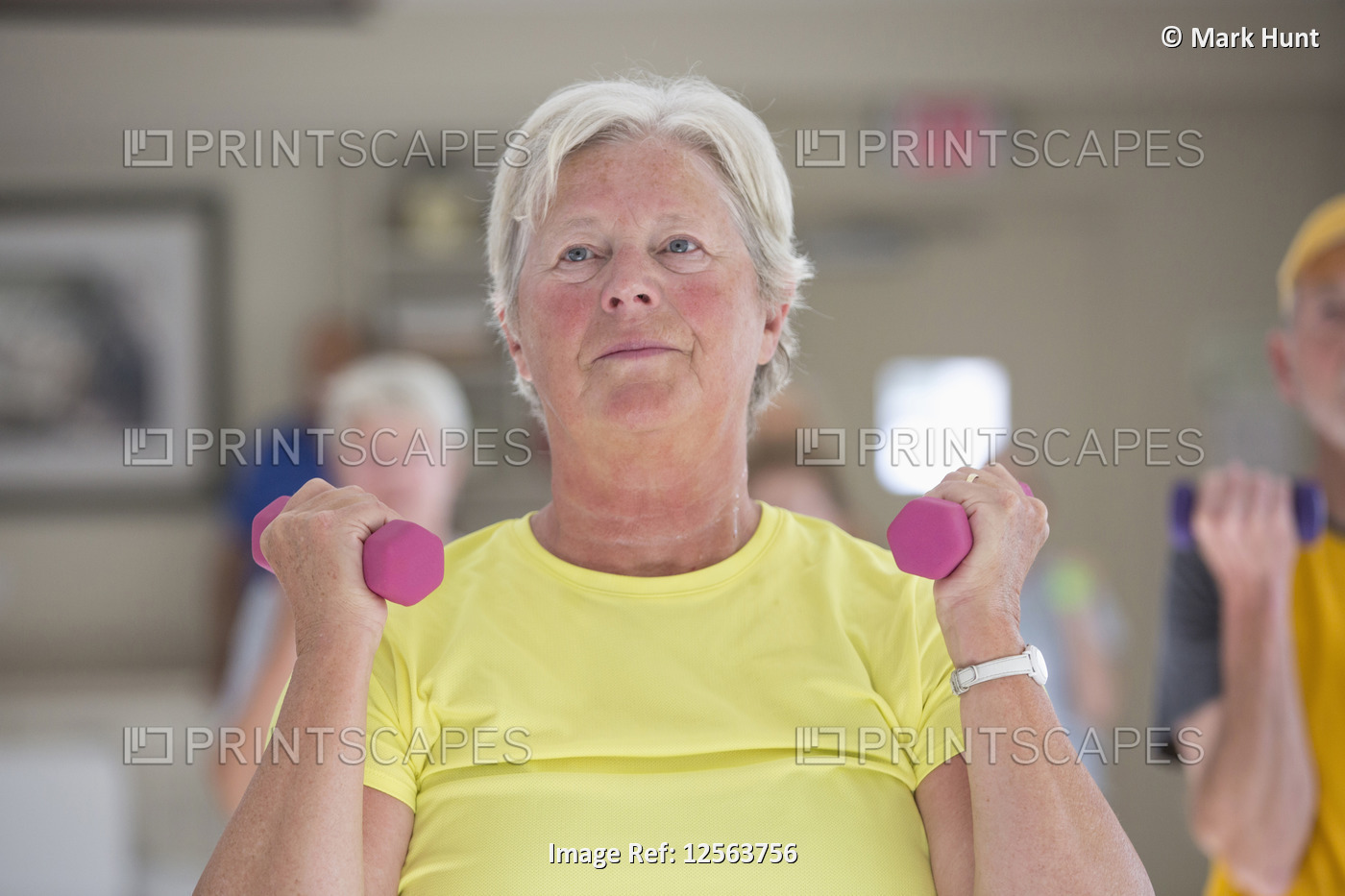 Happy senior woman exercising in gym