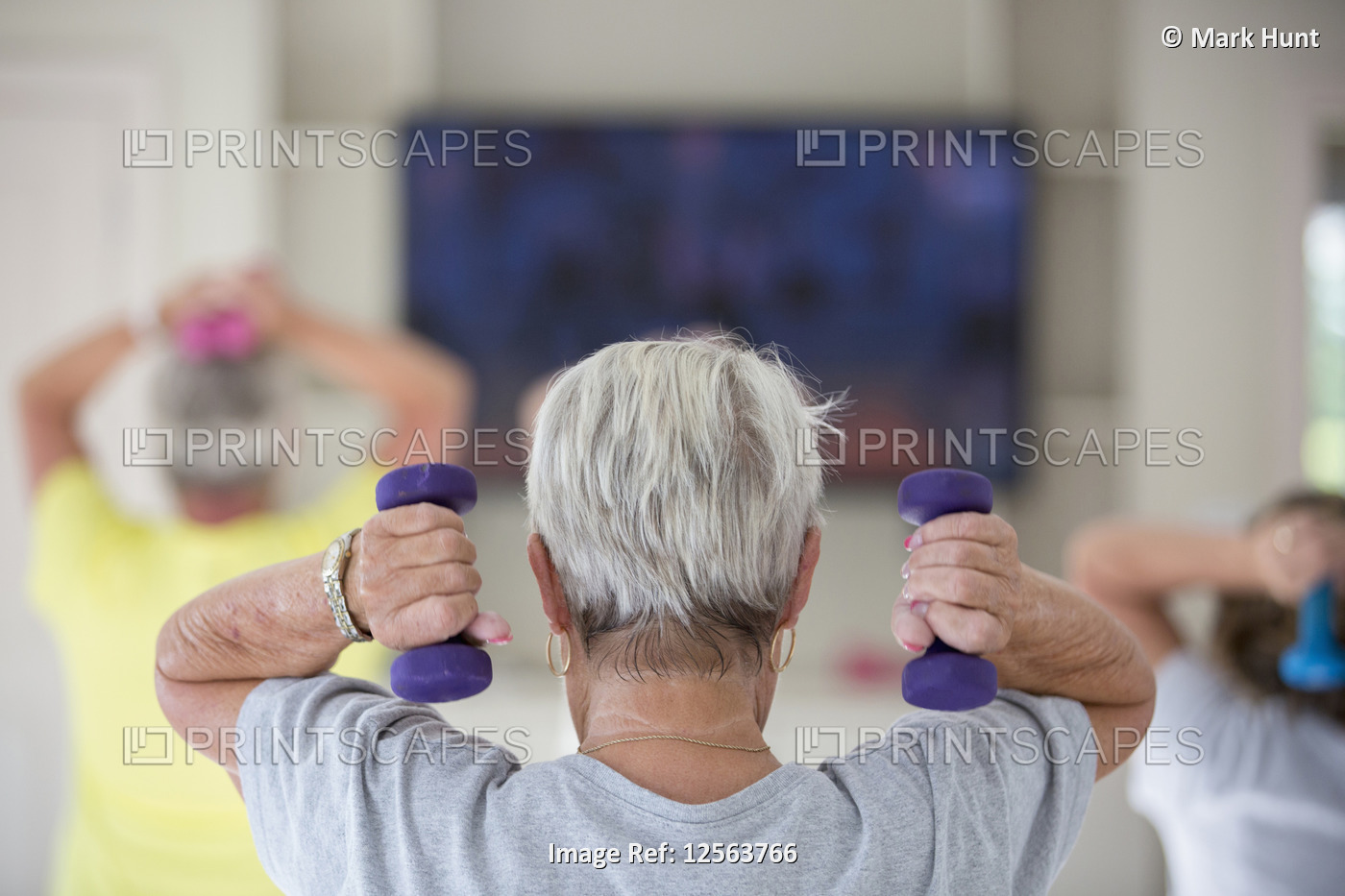 Rear view of senior woman exercising in gym