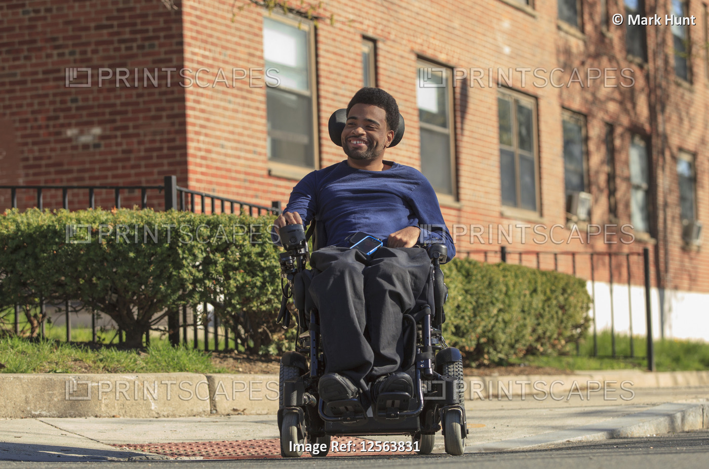 Happy African American man with Cerebral Palsy using his power wheelchair ...