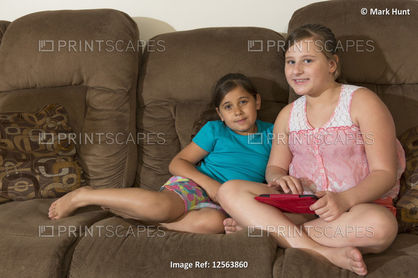 Happy Hispanic sisters playing an electronic game at home