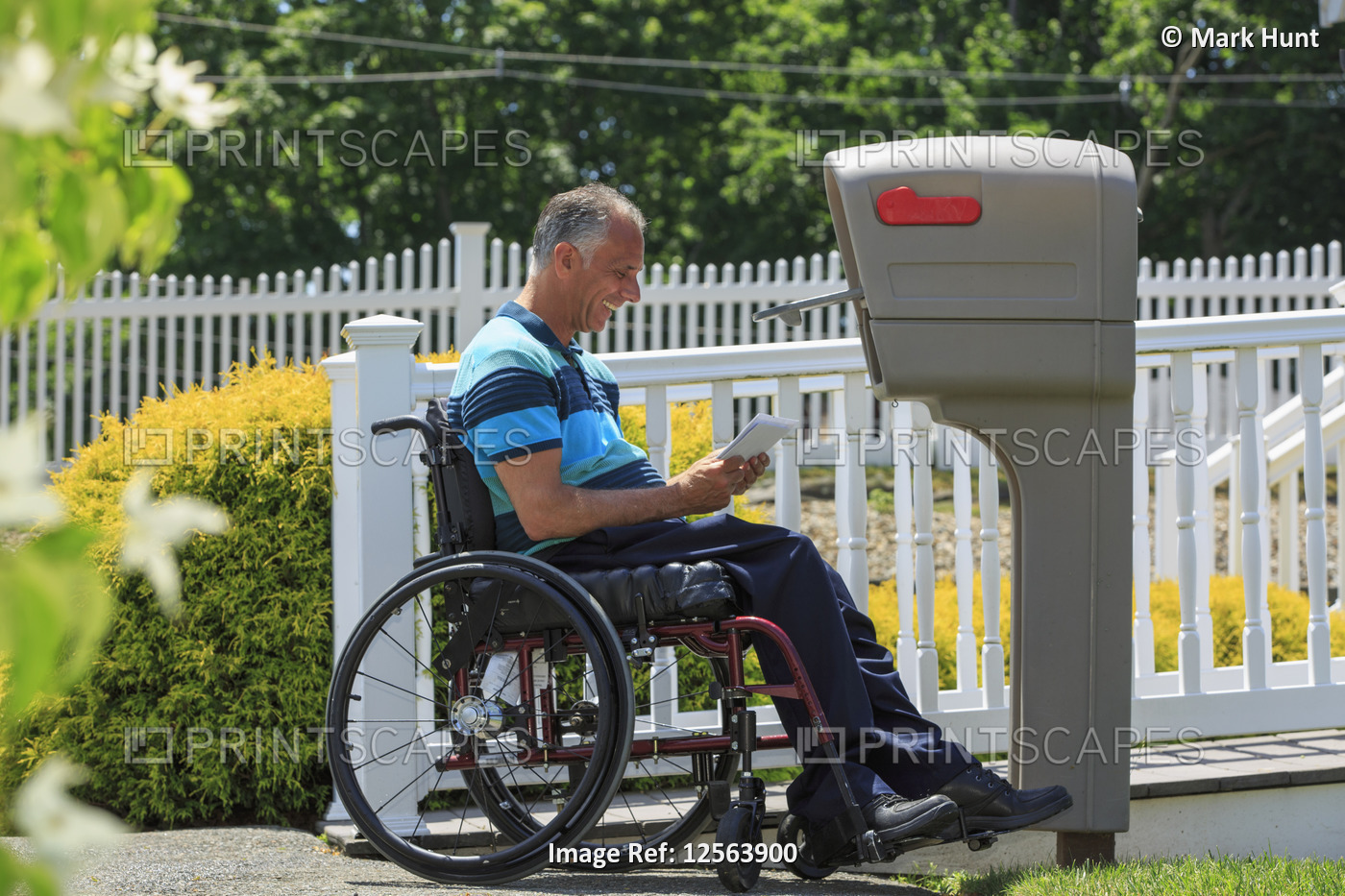Man with a Spinal Cord Injury in wheelchair getting his mail
