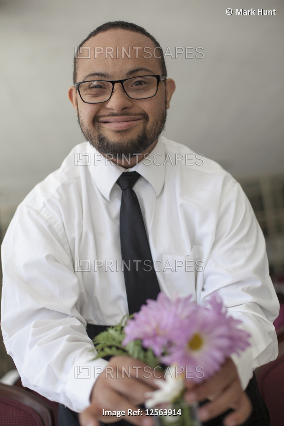 Portrait of happy African American man with Down Syndrome as a waiter fixing ...