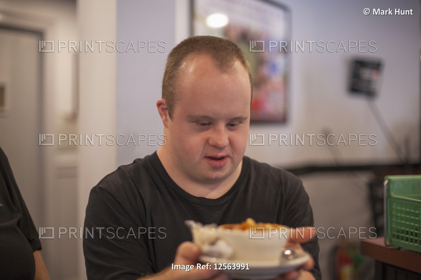 Waiter with Down Syndrome carrying food in a restaurant