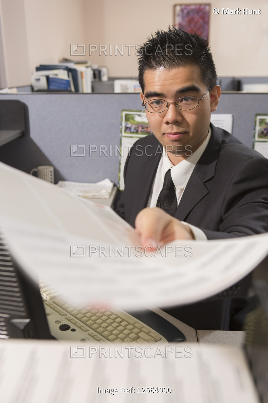 Asian man with Autism doing paperwork in an office