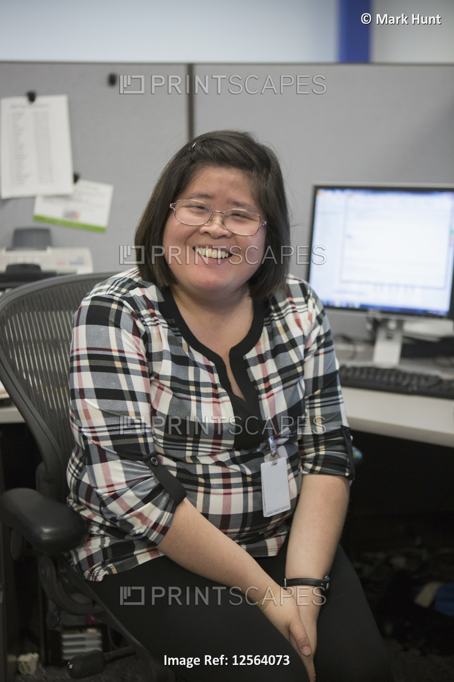 Portrait of happy Asian woman with a Learning Disability smiling in office