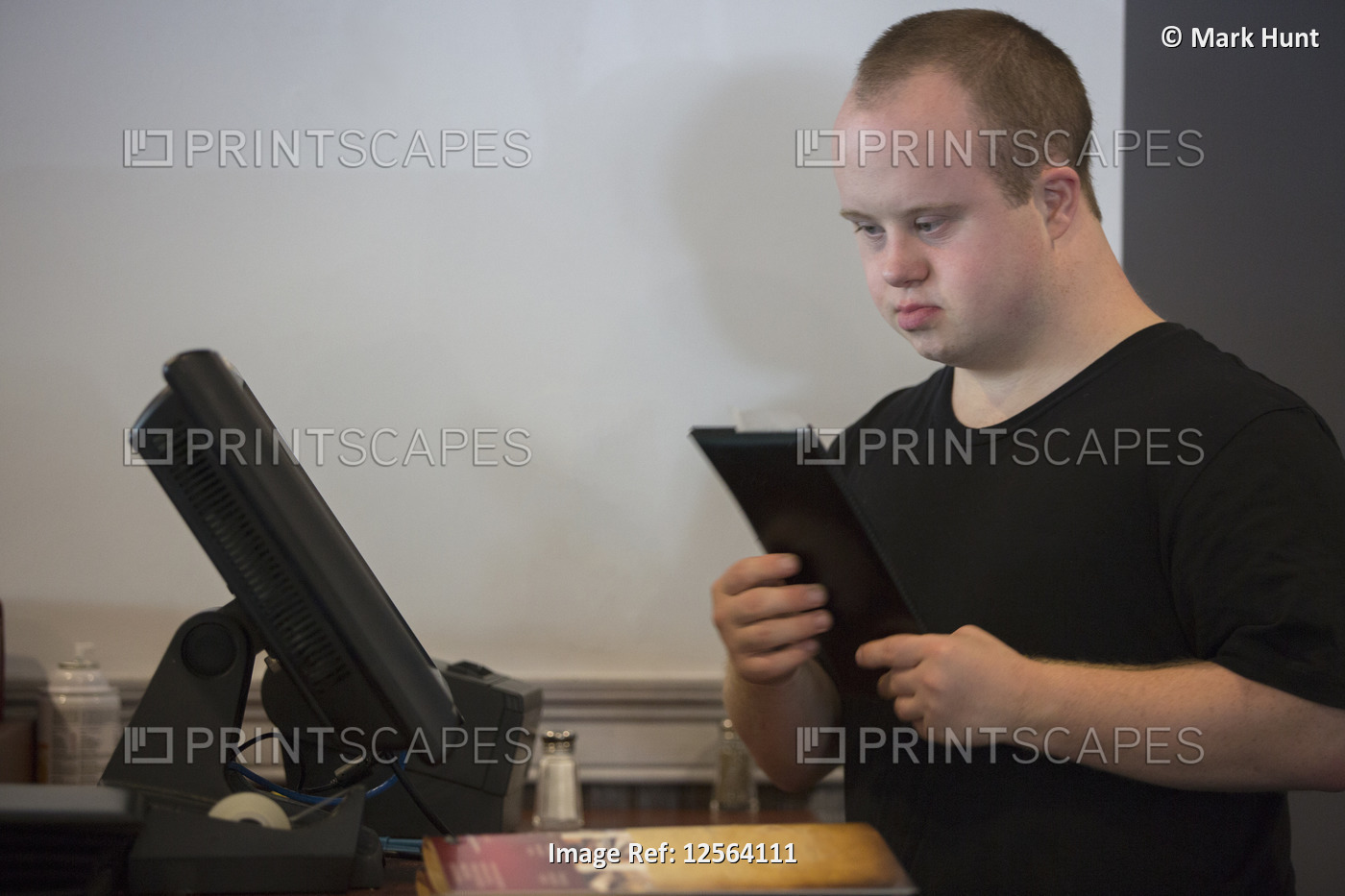 Waiter with Down Syndrome entering a sale on the computer