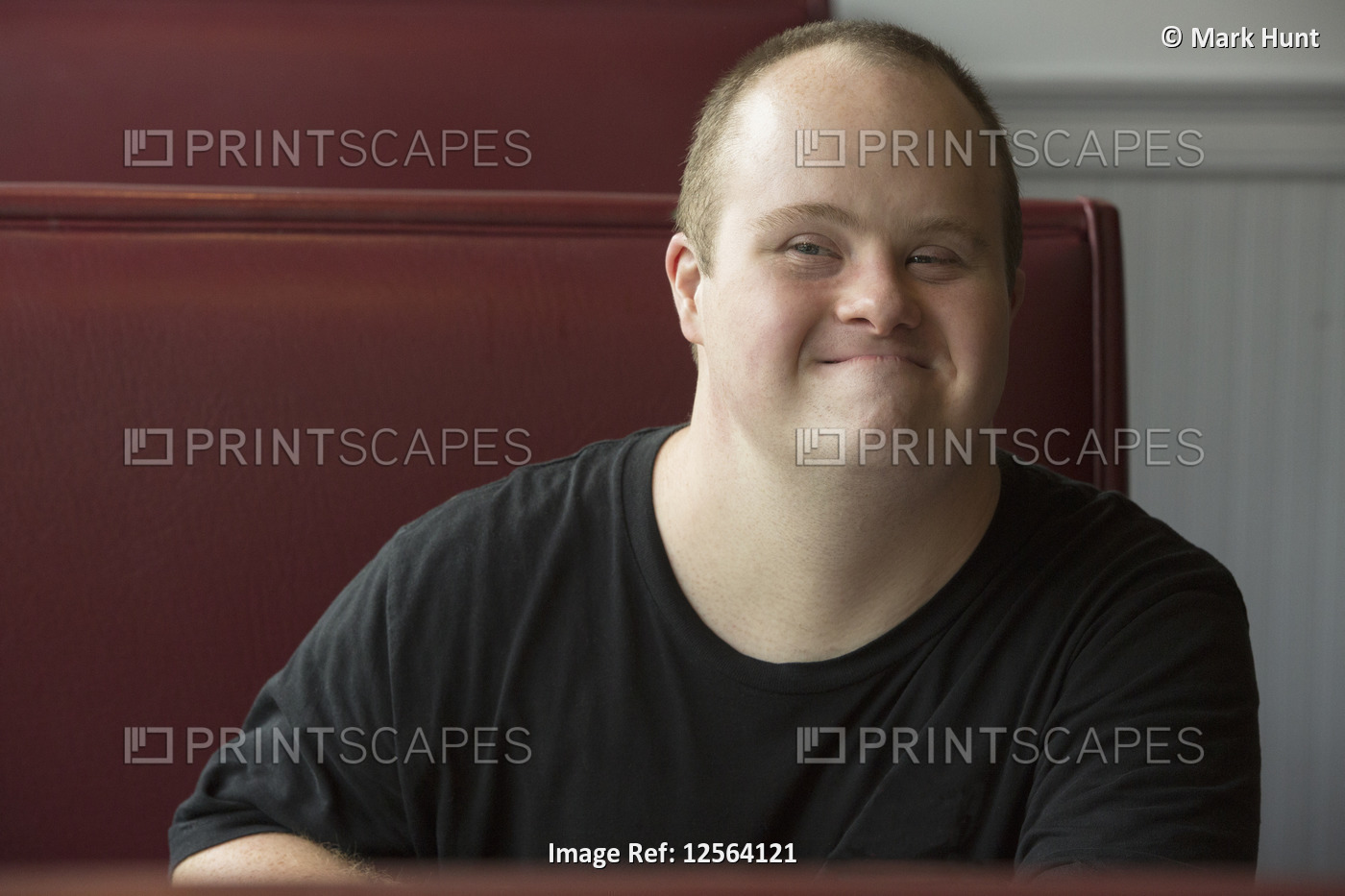Portrait of happy waiter with Down Syndrome in a restaurant
