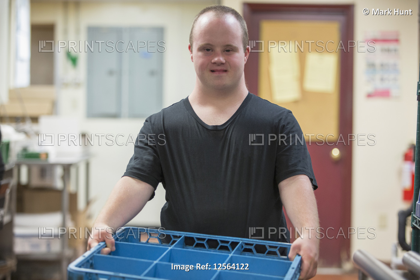 Waiter with Down Syndrome working in the kitchen of a restaurant
