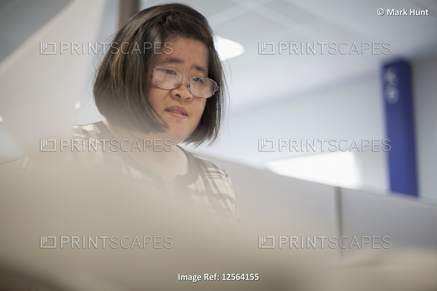 Asian woman with a Learning Disability working at a copy machine
