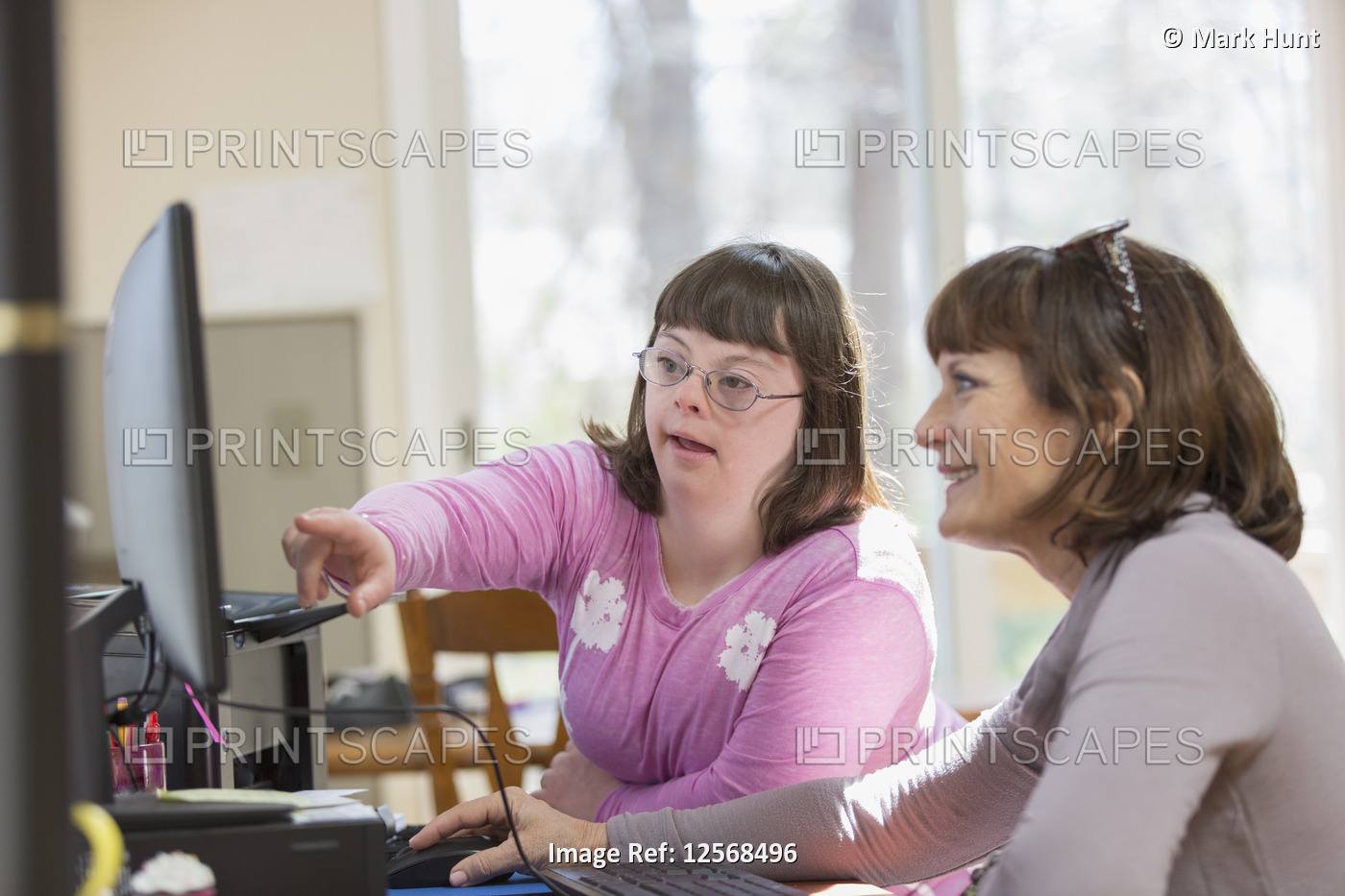 Girl with Down Syndrome and her mother using the computer