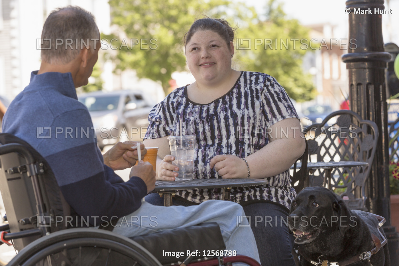Woman with Visual Impairment sitting at a cafe with her father and service dog