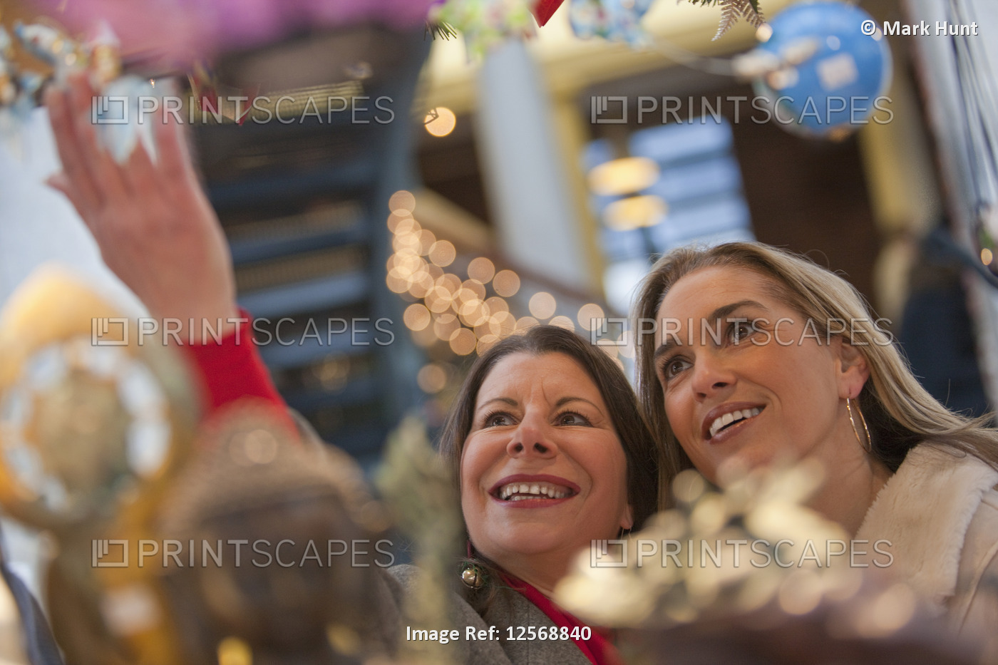 Two women looking at Christmas decorations in a shop