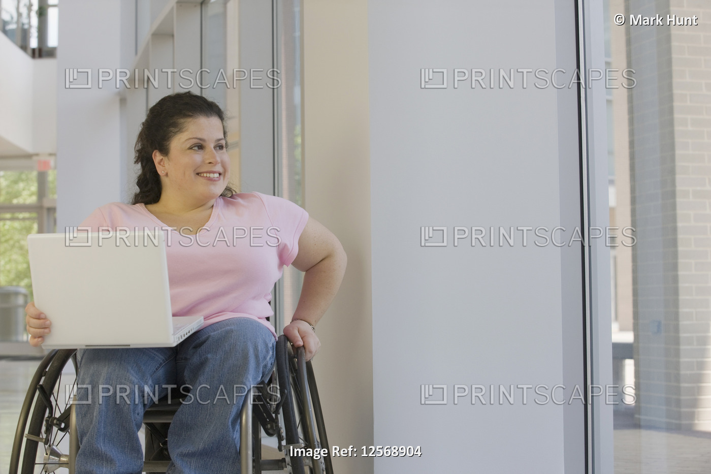 Woman with Spina Bifida sitting in a wheelchair and using a laptop