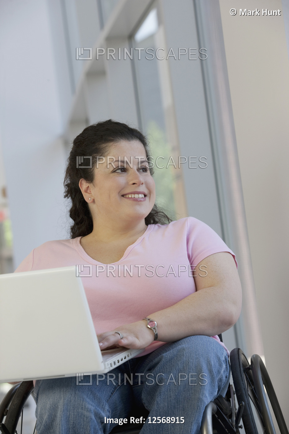 Woman with Spina Bifida sitting in a wheelchair and using a laptop