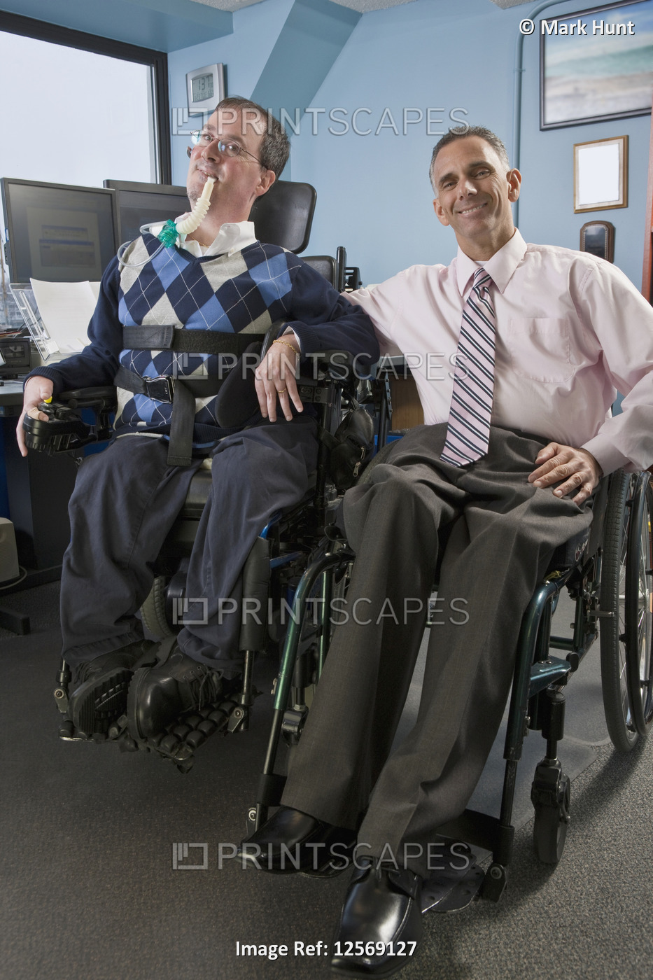 Two businessmen in an office, one with muscular dystrophy and breathing ...