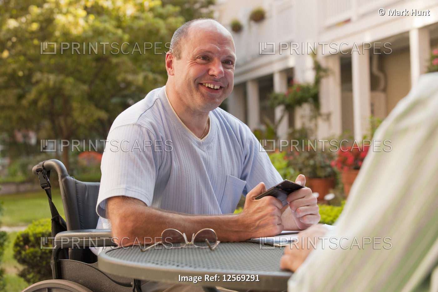 Businessman with Friedreich's Ataxia text messaging on a mobile phone with hand ...