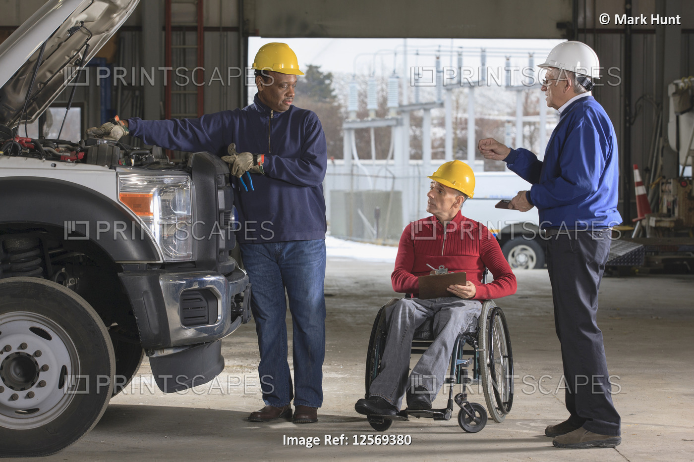 Power plant engineers one with spinal cord injury reviewing utility truck ...