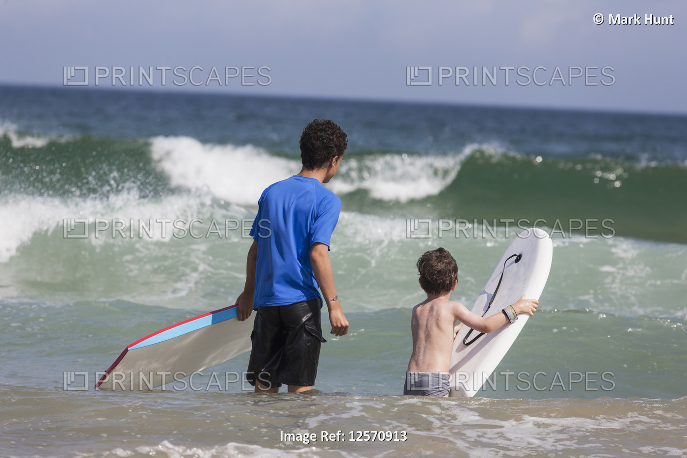 Two brothers surfing in the ocean