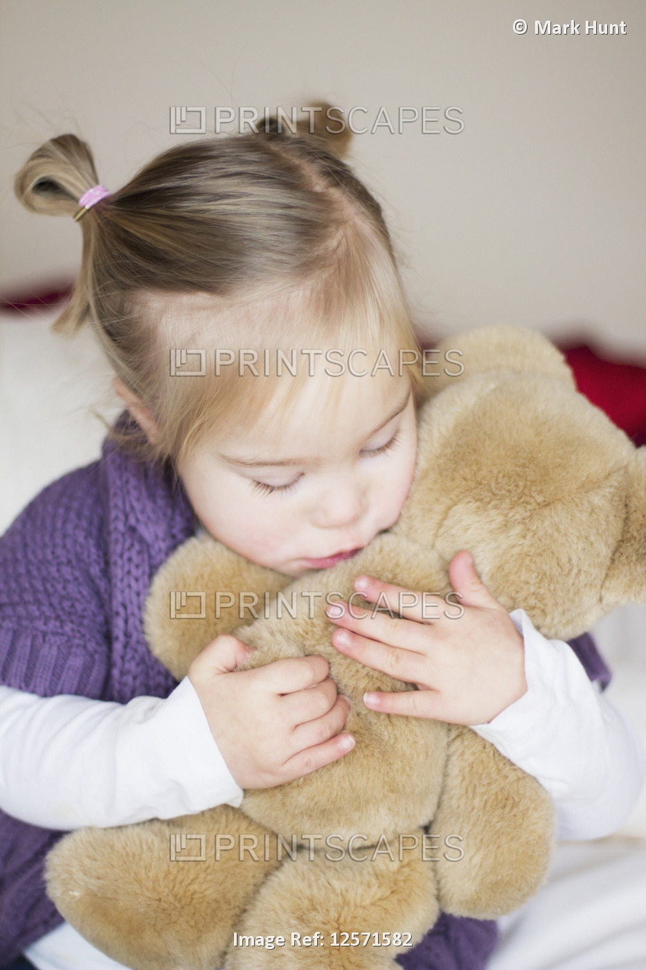 A Young Girl With Down Syndrome Cuddles With Her Teddy Bear; Cambridge, England