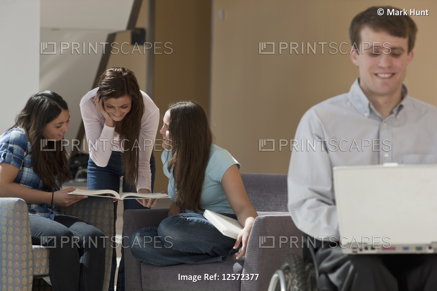College students study in a common area with a male student in a wheelchair in ...