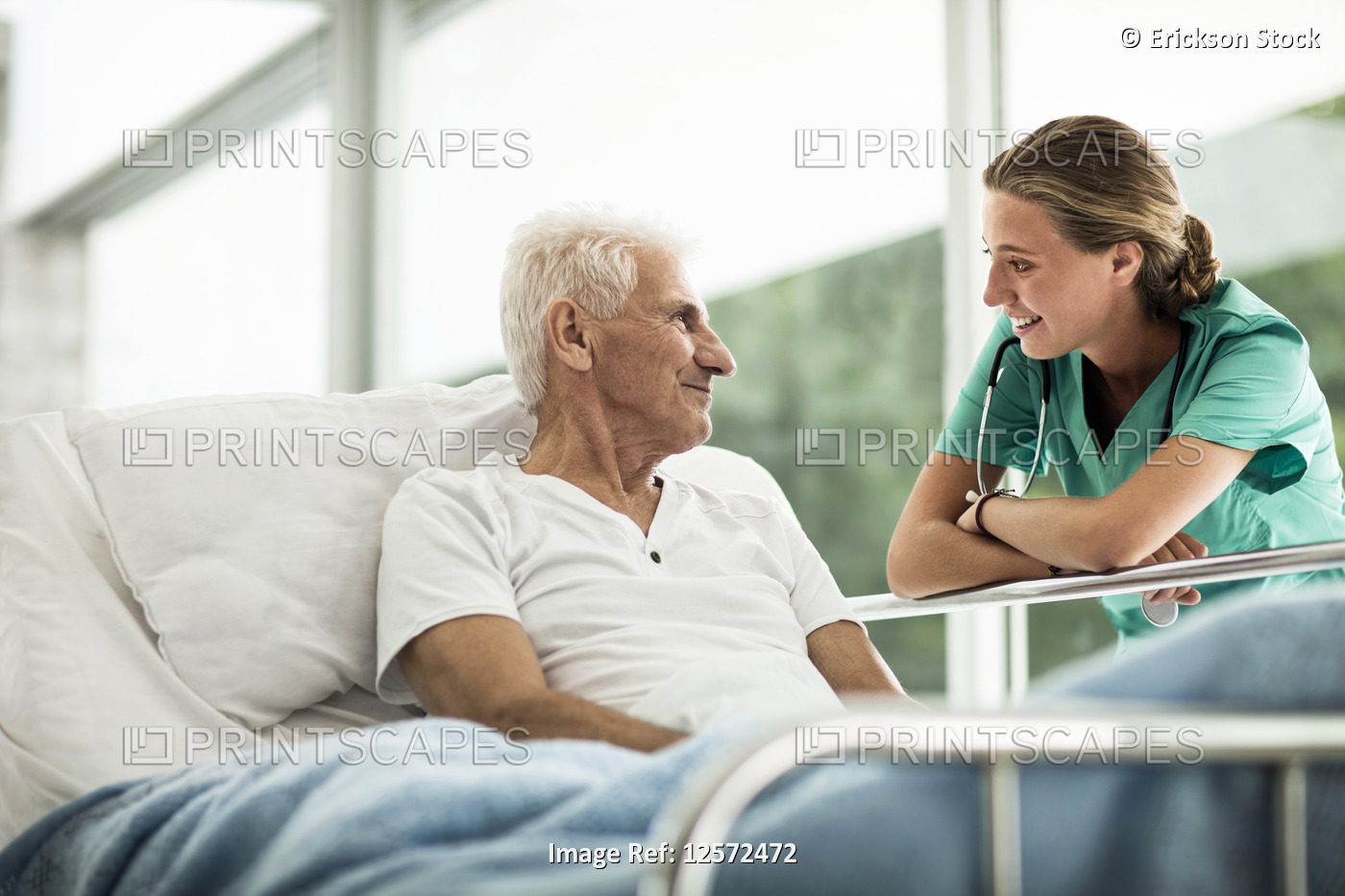Portrait of a senior man in a hospital bed,  and a young female doctor